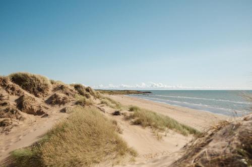a sandy beach with the ocean in the background at Cozy House near Beach, City & Activities in Falkenberg