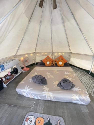 a mattress in a tent with three pillows on it at Amornkeeree Khao Sok Camping in Khao Sok