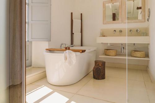 a white bathroom with a tub and a sink at Predi Son Jaumell Hotel Rural in Capdepera