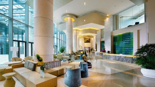 a lobby of a building with tables and chairs at Holiday Inn Shanghai Pudong Kangqiao by IHG - Free shuttle bus to Disney land, Ins Swimming Pool in Shanghai