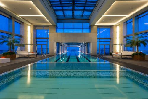 a swimming pool in a building with windows at Holiday Inn Shanghai Pudong Kangqiao by IHG - Free shuttle bus to Disney land, Ins Swimming Pool in Shanghai