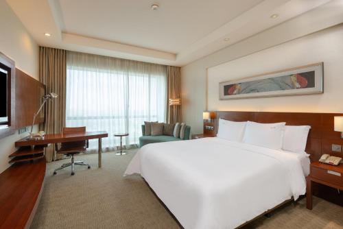 a hotel room with a large white bed and a desk at Holiday Inn Shanghai Pudong Kangqiao by IHG - Free shuttle bus to Disney land, Ins Swimming Pool in Shanghai