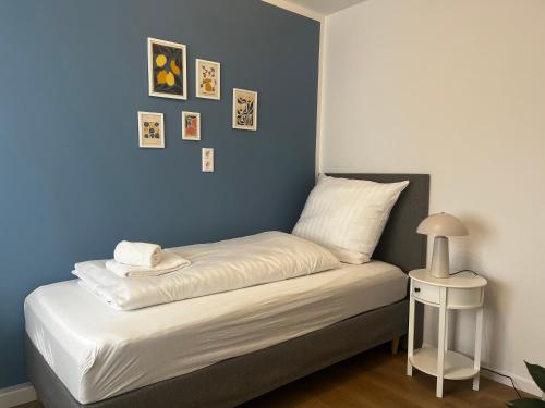 a bed in a room with a blue wall at SHINY HOMES - Modern & Cozy Stay in Bielefeld Mitte in Bielefeld