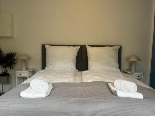 a bed with two towels on top of it at SHINY HOMES - Modern & Cozy Stay in Bielefeld Mitte in Bielefeld