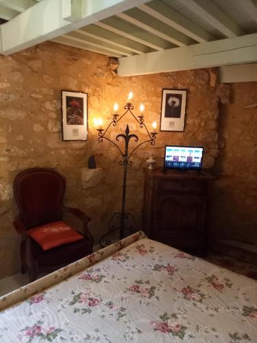 a bedroom with a bed and a chair in a room at chambre d hôtes les remparts in Saint-Cyprien