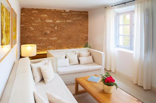 a living room with a white couch and a table at Predi Son Jaumell Hotel Rural in Capdepera