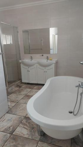 a bathroom with two sinks and a large white tub at A call for all guests in Pretoria
