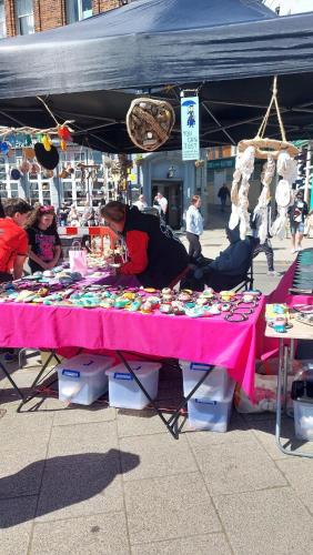 a woman sitting at a table with a pink table cloth at Clifftop Mews - Westcliff - Ramsgate - Pet friendly! in Kent