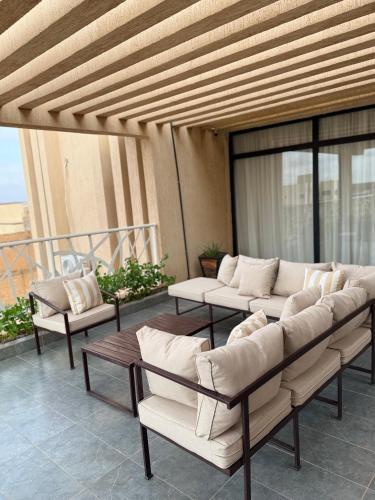 a patio with couches and tables on a balcony at Kalinou Niamey in Niamey