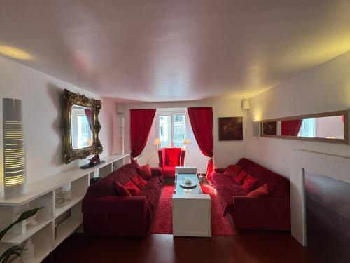 a living room with red couches and a fireplace at Red Flat Paris in Paris