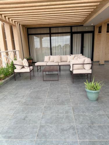 a patio with couches and tables in a building at Kalinou Niamey in Niamey
