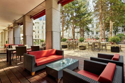 a patio with couches and tables and chairs at Hamburg Marriott Hotel in Hamburg