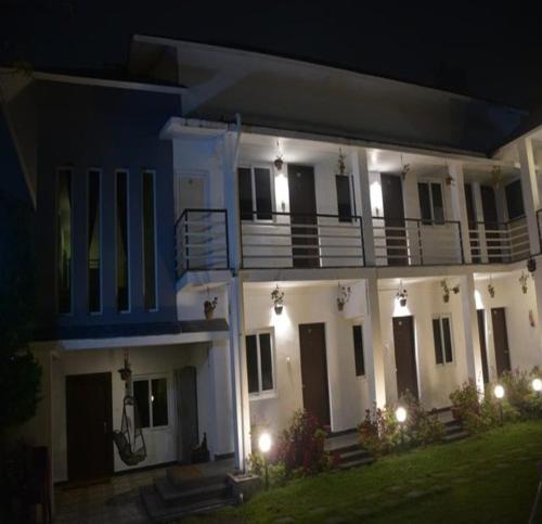 a large white house at night with lights at Magizham Homestay in Kodaikānāl