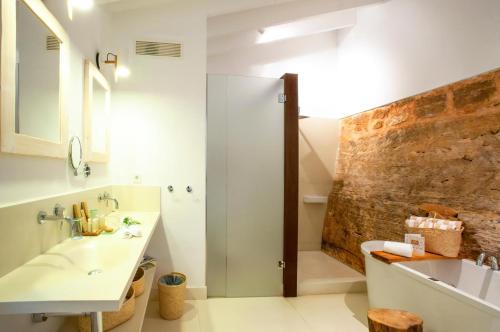 a bathroom with a shower and a sink and a tub at Predi Son Jaumell Hotel Rural in Capdepera