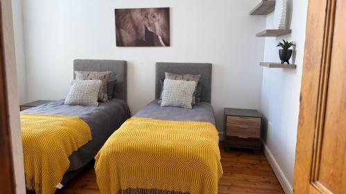 two beds sitting next to each other in a room at Obs Centre The Lookout in Cape Town