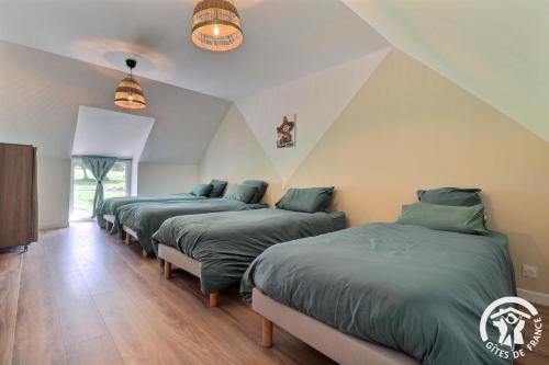 eine Reihe von 4 Betten in einem Zimmer in der Unterkunft Le cocon des korrigans in Paimpont