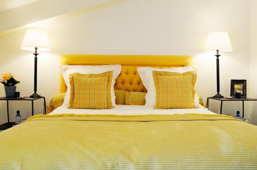 a bedroom with a bed with yellow sheets and two lamps at Chalet La Forestière in Saint-Paul-en-Chablais