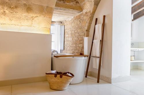 a bathroom with a bath tub and a sink at Predi Son Jaumell Hotel Rural in Capdepera