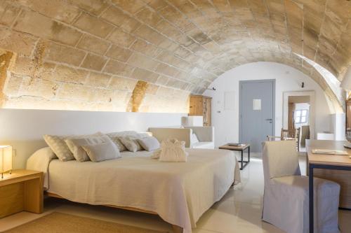 a bedroom with a large bed with a stone wall at Predi Son Jaumell Hotel Rural in Capdepera