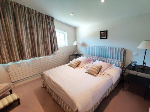 a bedroom with a bed with a blue headboard and pillows at Chalet La Forestière in Saint-Paul-en-Chablais