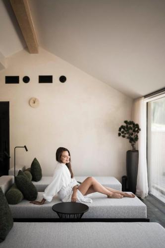 a woman sitting on a couch in a living room at Hotel Plan de Gralba - das Berghotel in Selva di Val Gardena