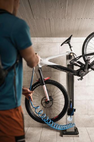 a person is washing a bike on a stand at Hotel Plan de Gralba - das Berghotel in Selva di Val Gardena
