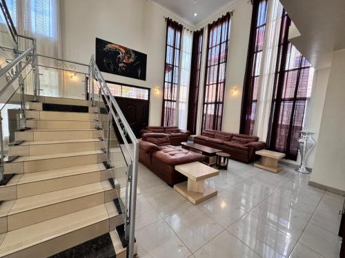 a living room with a staircase with a couch and a table at Sunset suit by Iwacu Stays in Kigali