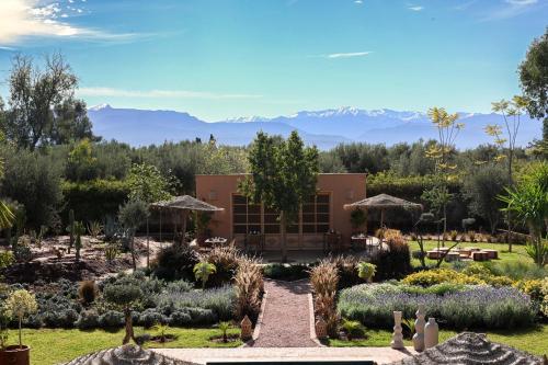 a view of a garden with mountains in the background at Villa Naël Marrakech in Marrakech