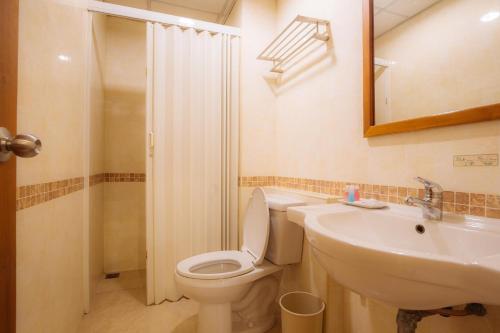 a bathroom with a toilet and a sink and a mirror at Metro Point Bangkok in Bangkok