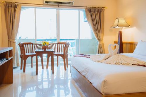 a bedroom with a bed and a table and chairs at Metro Point Bangkok in Bangkok