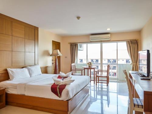 a hotel room with a bed and a table with chairs at Metro Point Bangkok in Bangkok