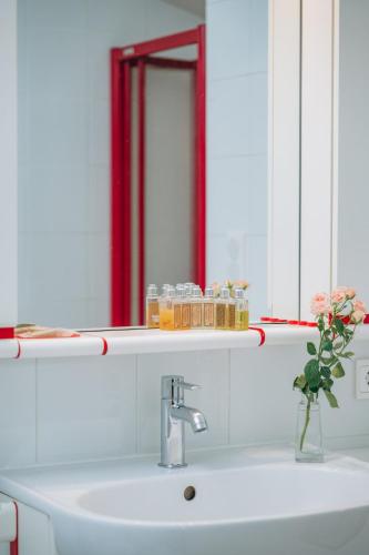 a bathroom sink with a mirror and a vase of flowers at Chalet La Forestière in Saint-Paul-en-Chablais