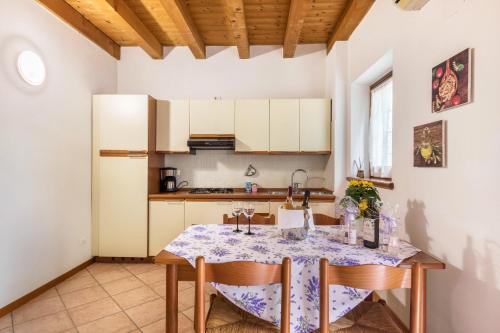 a kitchen with a table with chairs and a sink at AGRITURISMO COLOMBARE TEBOI in Lazise