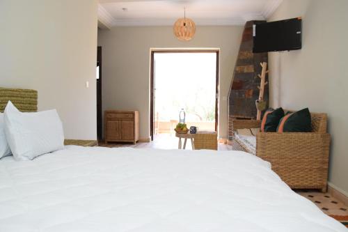 a bedroom with a white bed and a large window at Wild Valley Ouirgane in Ouirgane