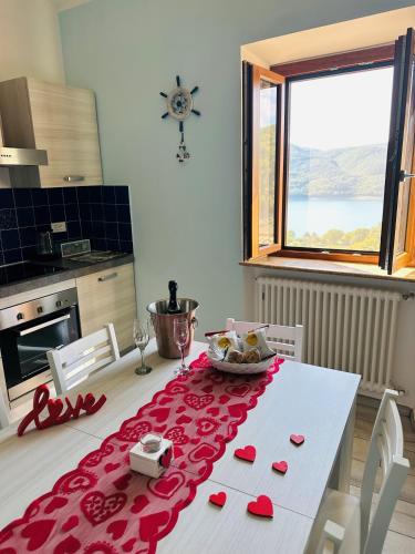 a kitchen with a table with a red table cloth at La Dimora del Turano in Castel di Tora