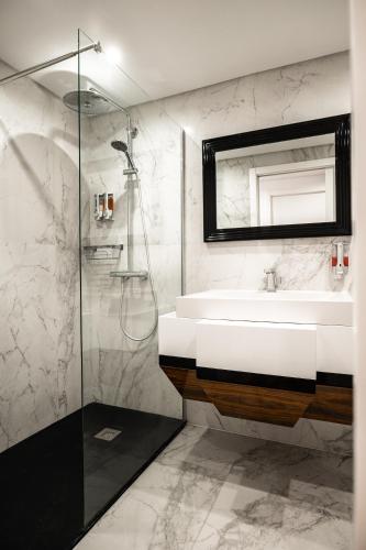 a bathroom with a sink and a glass shower at Loft Prestige in Leiria