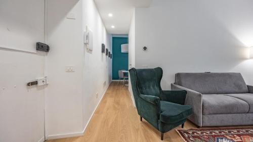 una sala de estar con un sofá y una silla en Testaccio's Heart by Rentbeat, en Roma