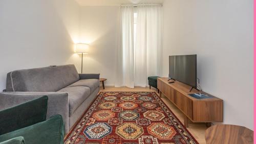 Una sala de estar con un sofá y un televisor de pantalla plana. en Testaccio's Heart by Rentbeat, en Roma