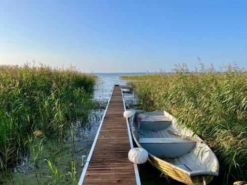two boats are docked next to a wooden dock at Solvik Lakehouse & Outdoor Spa in Vreta Kloster