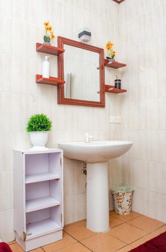 a bathroom with a sink and a mirror at Bright Diani Studio with King Bed, 2min to Beach in Diani Beach