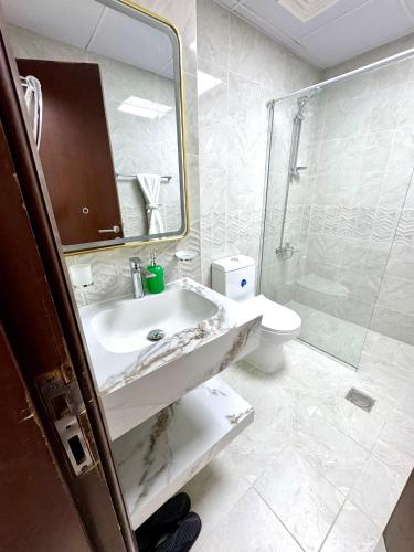 a bathroom with a sink and a shower and a toilet at Newly Furnished, Bright and Spacious Studio in France Cluster, International City in Dubai