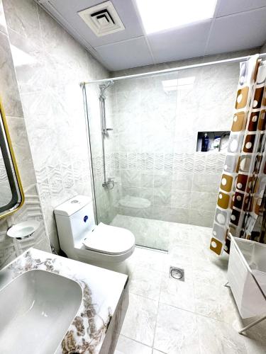 a bathroom with a toilet and a shower and a sink at Newly Furnished, Bright and Spacious Studio in France Cluster, International City in Dubai