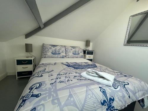 a bedroom with a bed with a blue and white bedspread at Chy An Lur in Redruth
