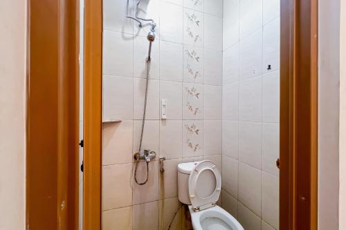a small bathroom with a toilet and a shower at JJ House Mitra RedDoorz in Jakarta