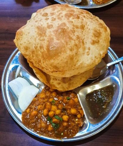 a plate of food with chickpeas and bread and dips at Purnima Resort Neil Island in Neil Island