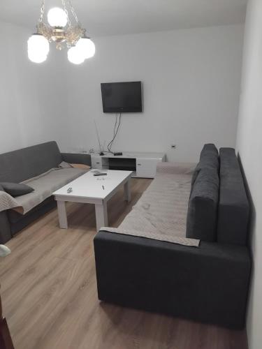 a living room with a black couch and a tv at Nadica Apartment in Struga
