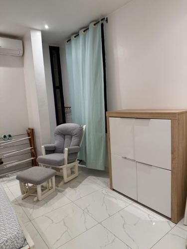 a living room with a chair and a dresser at Kalinou Niamey in Niamey