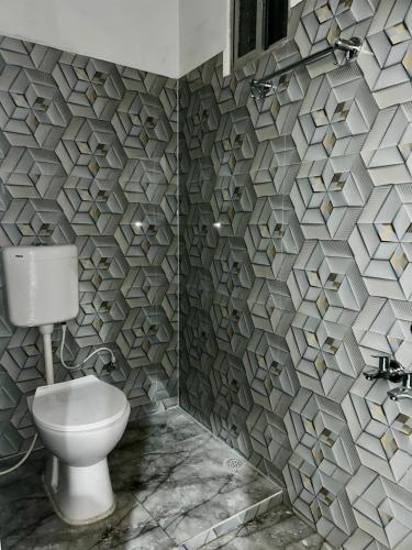 a bathroom with a toilet and a stone wall at The Boho House in Darbhanga
