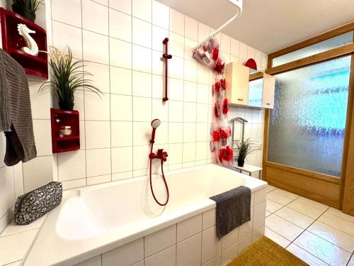 a bathroom with a white tub and a shower at FERIENWOHNUNGEN Krull App 02 in Ahrenshoop