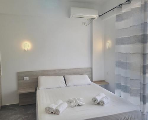 a bedroom with a white bed with towels on it at Villa Baka Studio Apartments in Sarandë